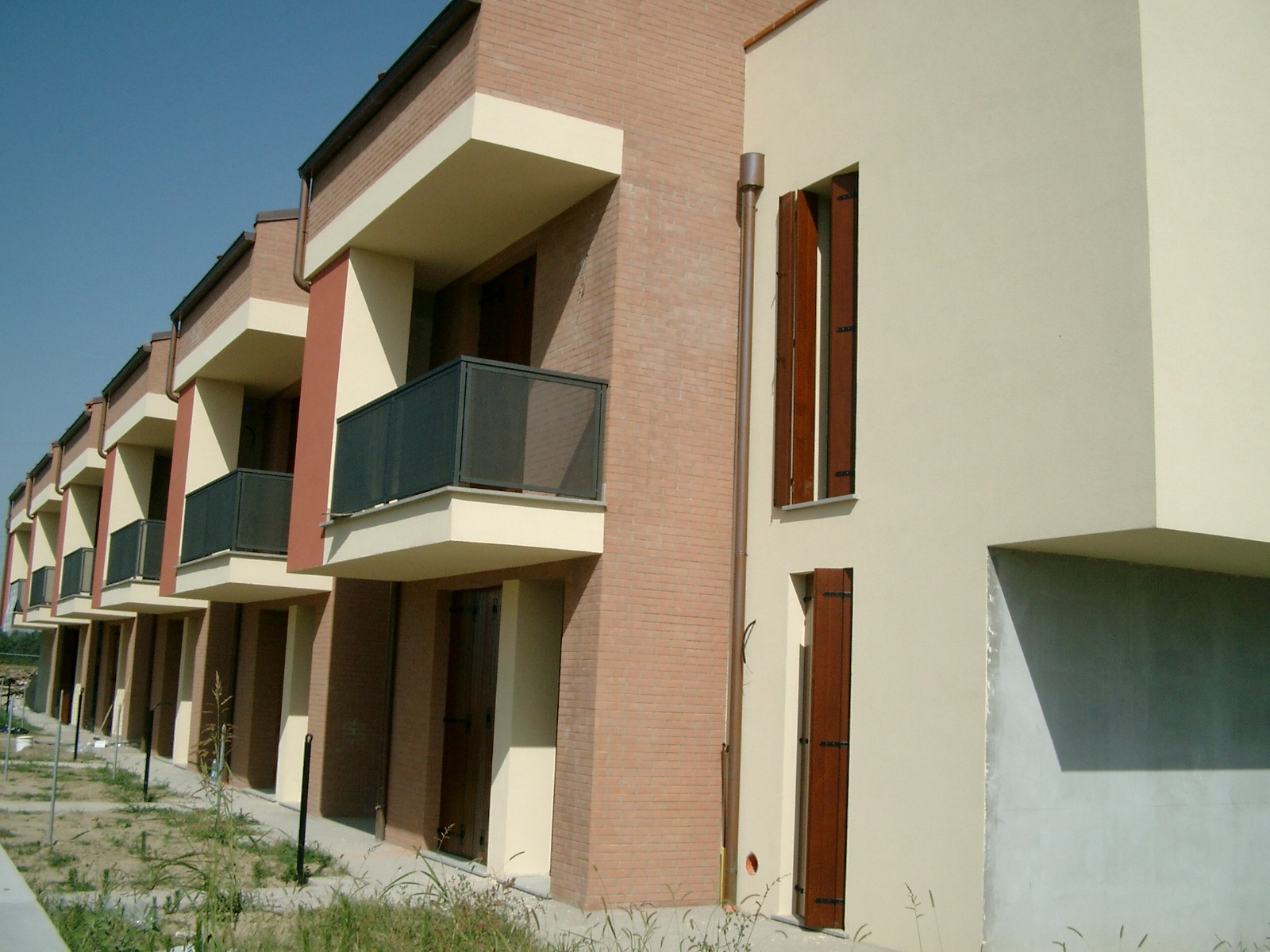 Edifici residenziali a Malalbergo con balconi e facciate in mattoni e intonaco